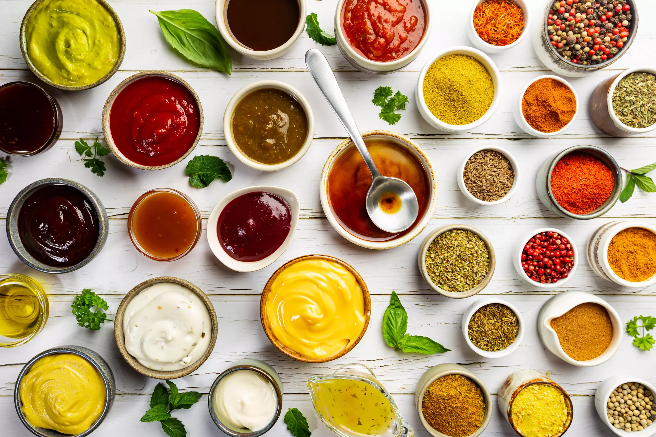 a white wooden counter covered in bowls of sauces