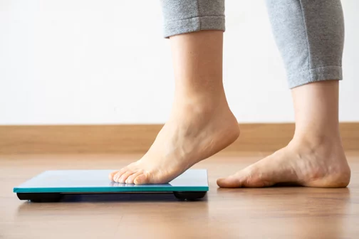 person stepping on to a scale