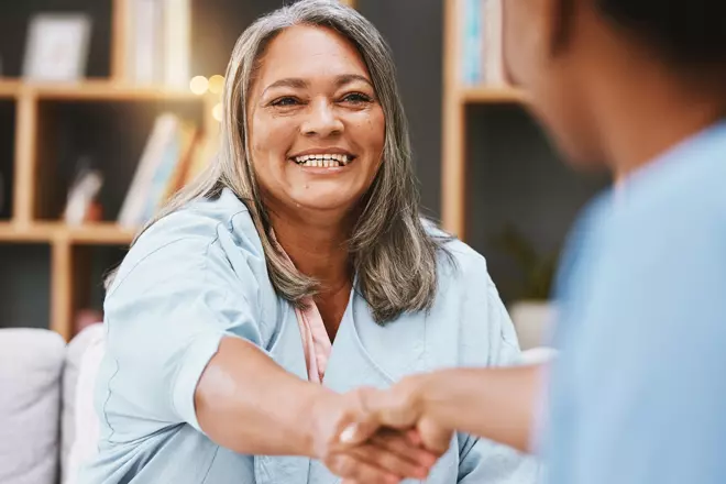 woman shaking the hand of a man.