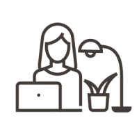 person at desk with laptop and desk lamp