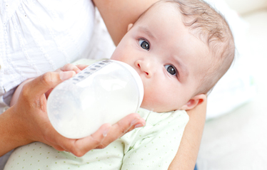 Baby drinking baby formula from bottle